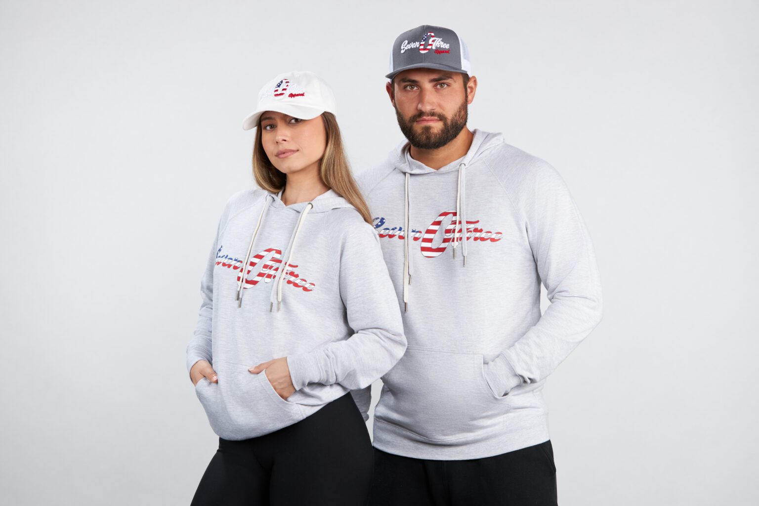 A man and woman wearing hats and sweatshirts.